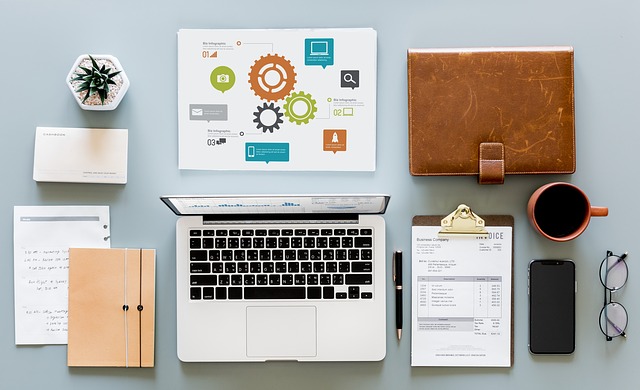 A desk with a laptop and papers